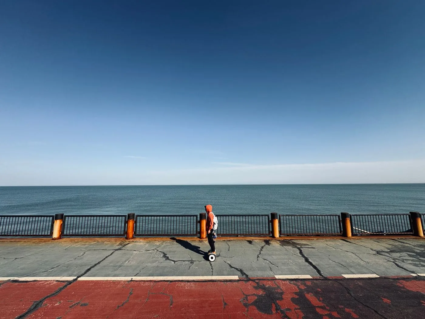 Personne sur un hoverboard le long d une promenade en bord de mer