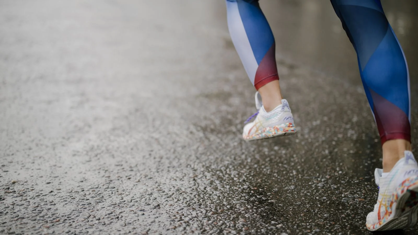 Coureur en chaussures de running sur une route mouillée