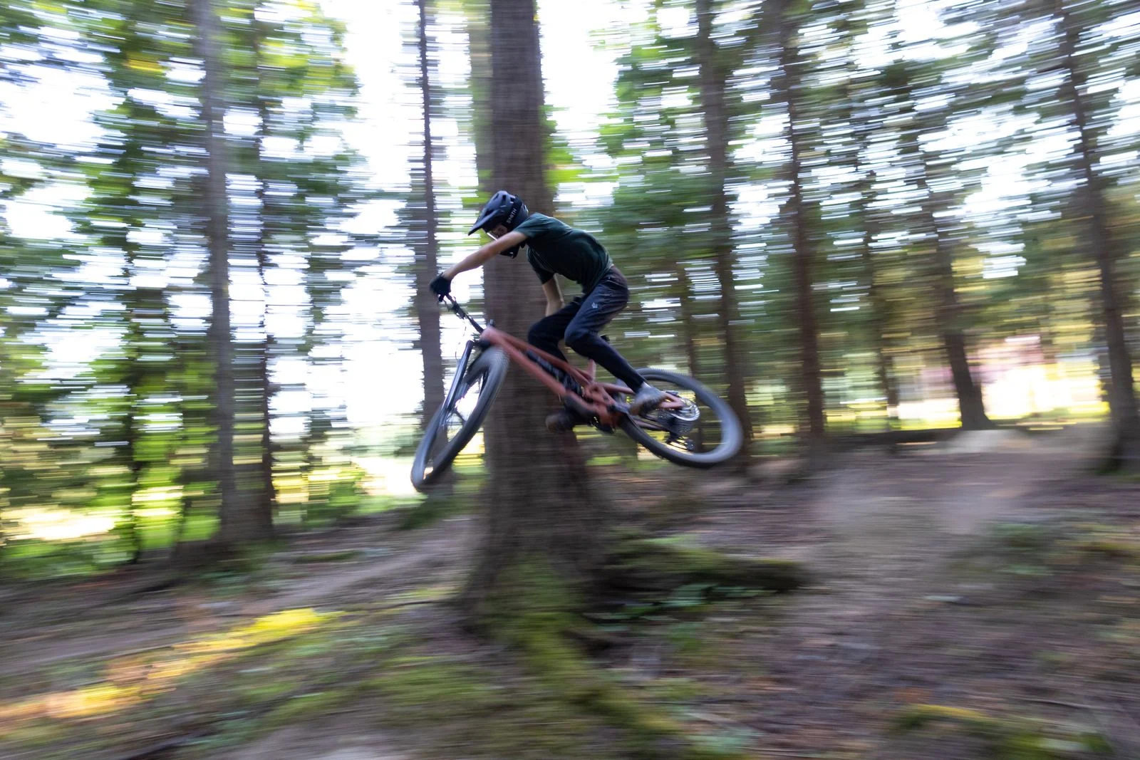 VTTiste en pleine descente rapide sur un sentier forestier